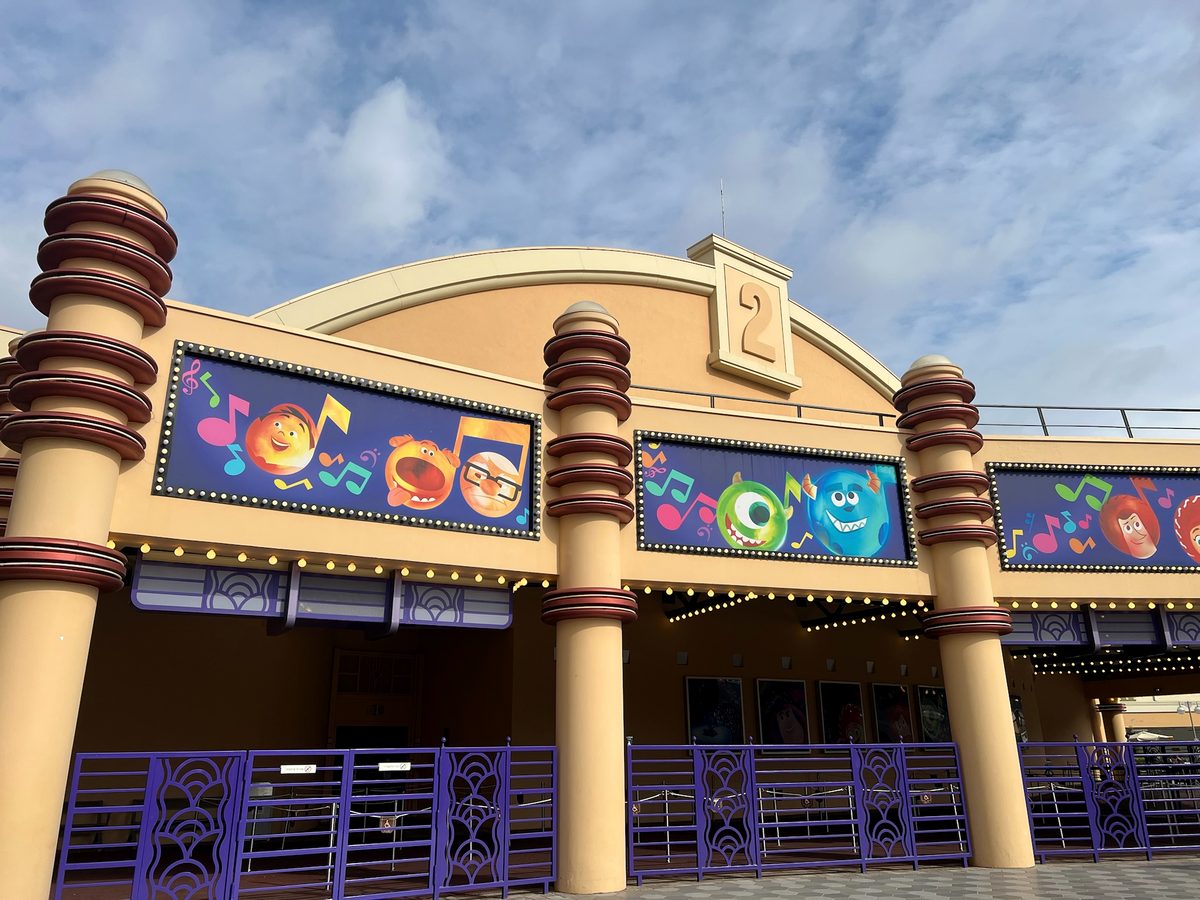 Colourful Pixar character banners along the Studio Theater frontage under a blue sky