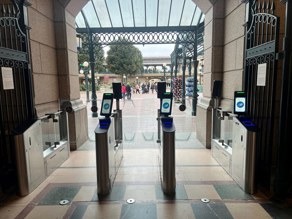 Ticket gates in a stone gateway of the Disneyland Hotel, opening onto the plaza inside Disneyland Park