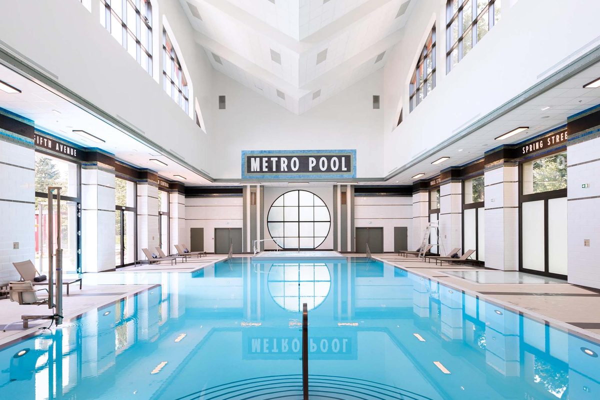 The Metro Pool, a long indoor pool tiled and signed like a New York subway station, with a large round window at the far end and a Metro Pool mosaic sign