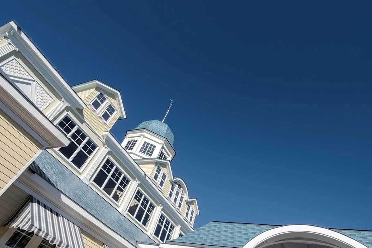 The pale-yellow clapboard, white trim and blue-slate cupola of Disney Newport Bay Club rising against a clear sky