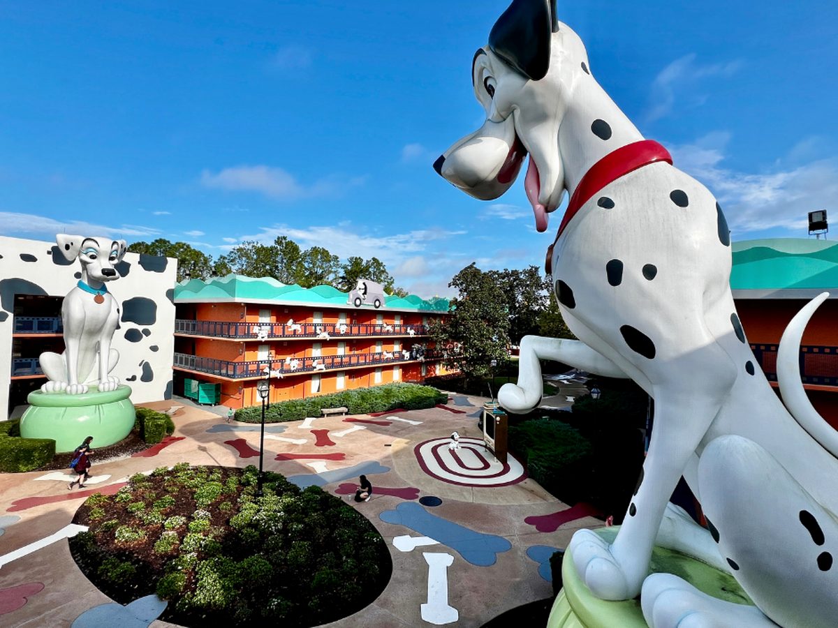 Two giant Dalmatian figures overlooking the 101 Dalmatians courtyard at Disney All-Star Movies, its pavement painted with bones and paw prints