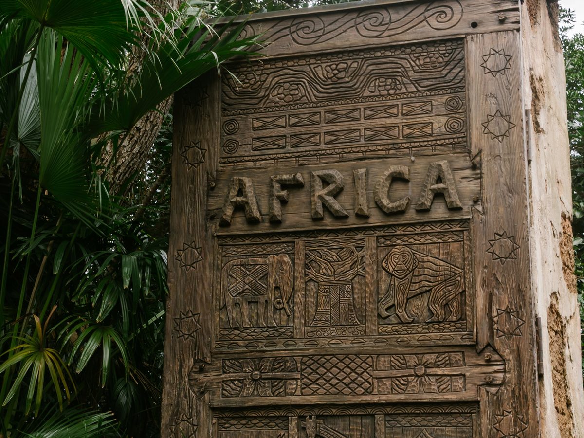 The carved wooden gateway into the Africa area of Animal Kingdom, the word Africa above panels of carved elephants and lions