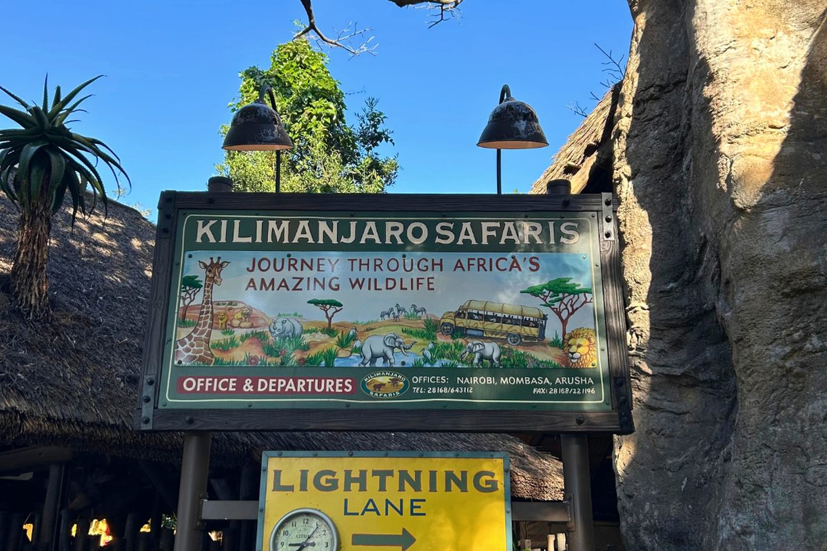 A safari truck of guests on Kilimanjaro Safaris at Animal Kingdom, driving through open savanna with animals grazing