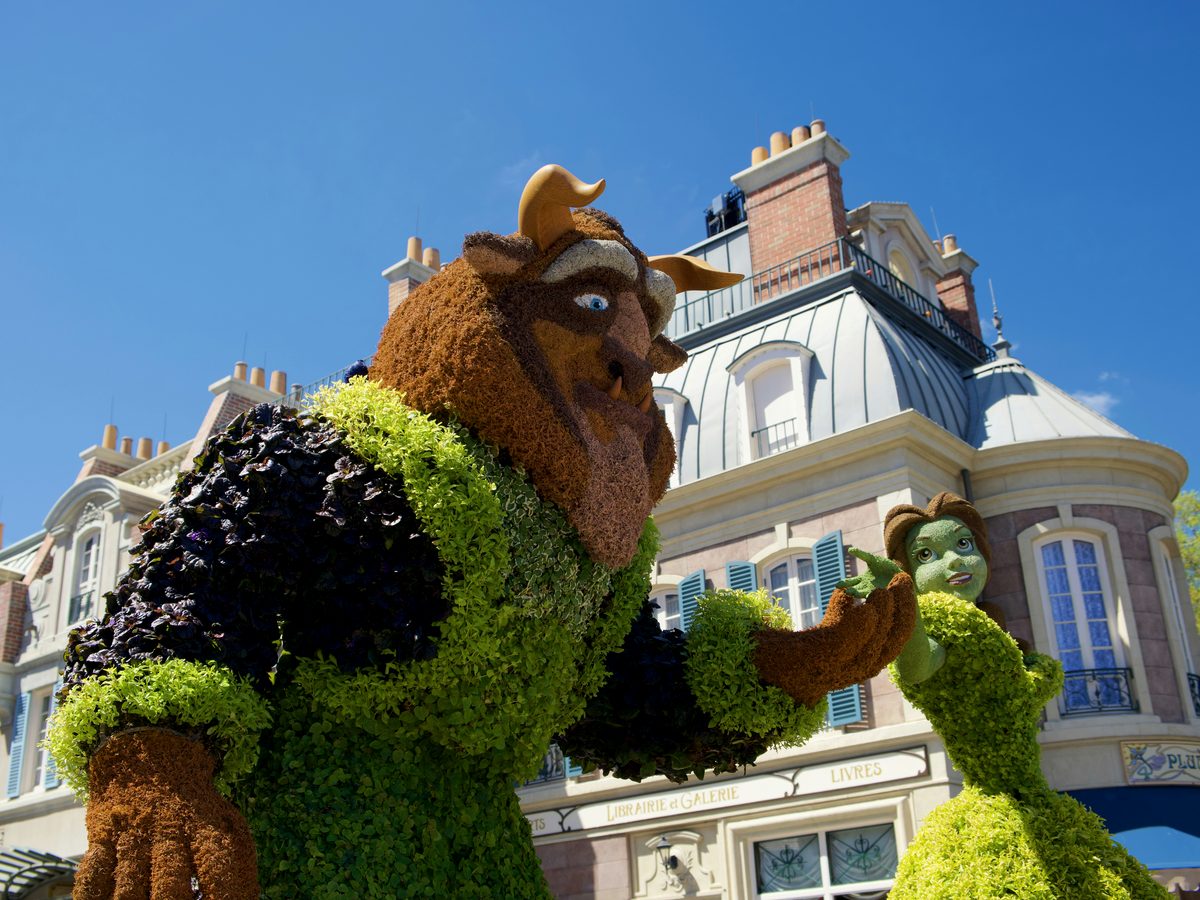 Beast and Belle topiary figures standing in front of the France pavilion