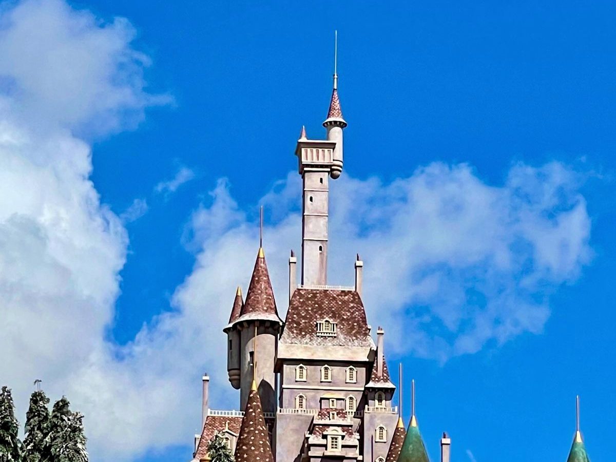 The towers of Beast's Castle against a blue sky at Magic Kingdom, the miniature castle that houses the Be Our Guest restaurant