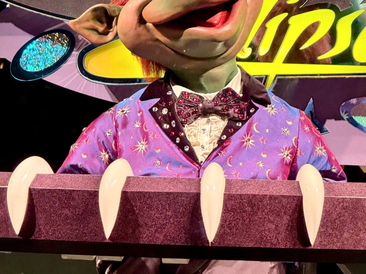 The Sonny Eclipse animatronic at Magic Kingdom, an alien lounge singer in a sparkly purple jacket performing on his small stage at Cosmic Ray's