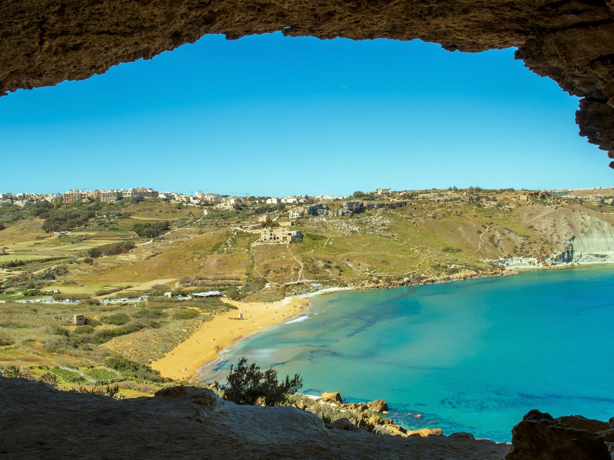 Red sand on Gozo, framed from a cave above the bay