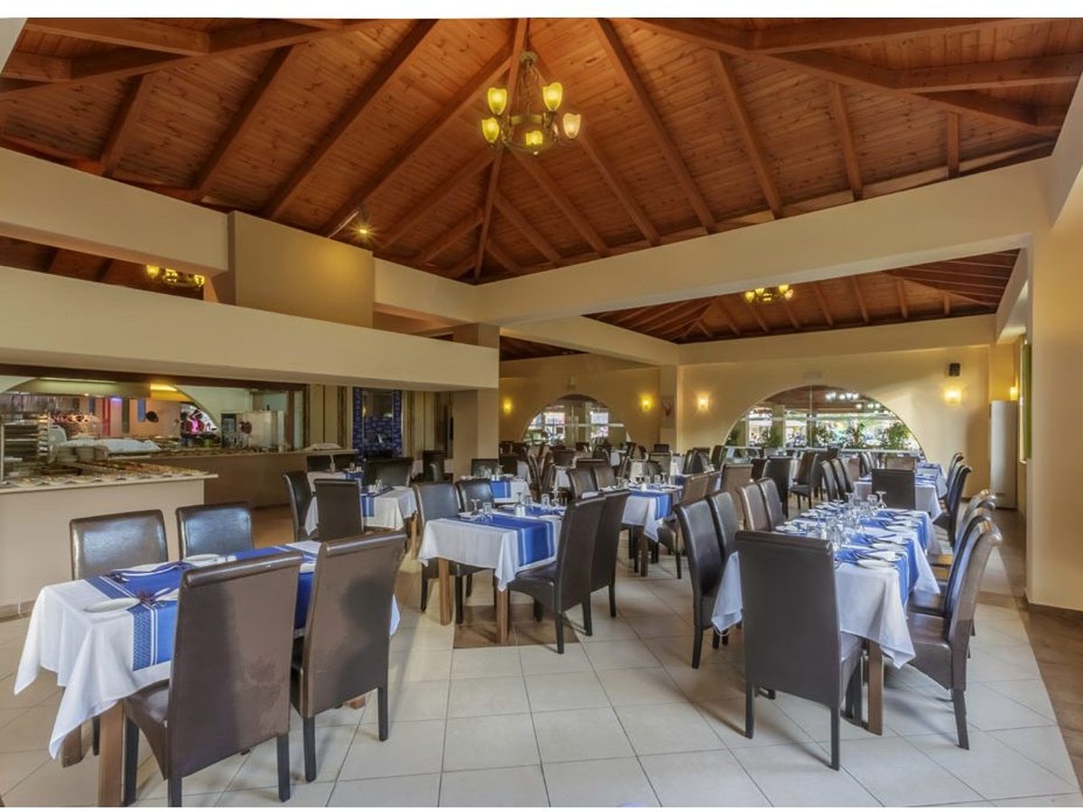 The indoor main buffet restaurant with a high timber vaulted ceiling, white-clothed tables with blue runners and buffet counters along one side.