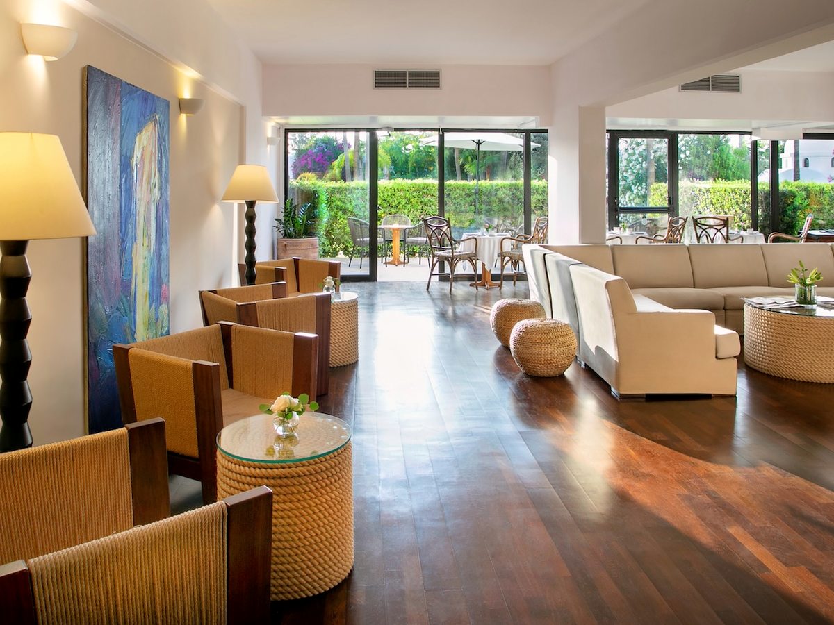 Indoor lounge with cream sofas and armchairs, low tables and a polished wooden floor.