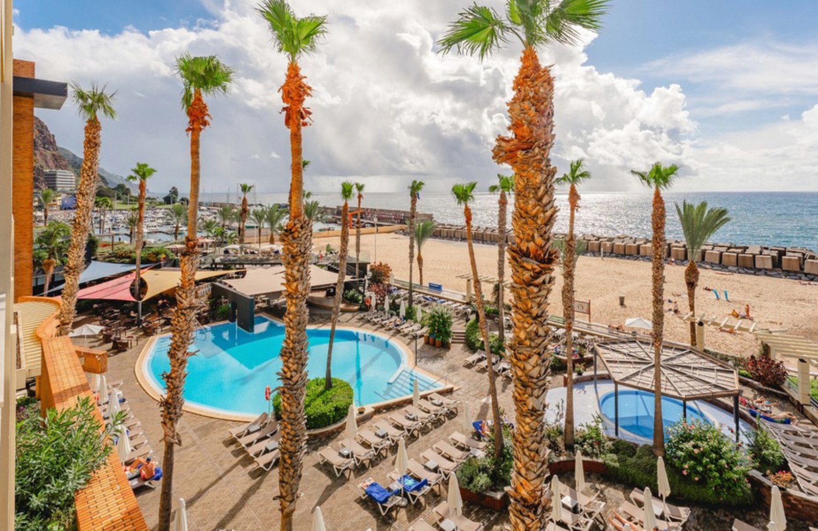 Calheta Beach hotel on the south-west coast of Madeira, built beside the fine yellow sand of Praia da Calheta with the harbour and the Atlantic beyond.