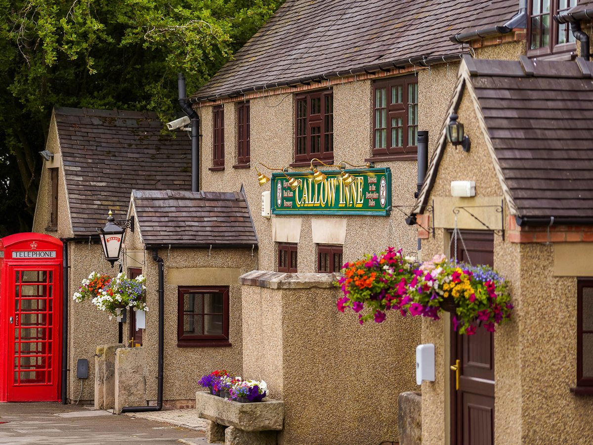 The Callow Inn, a cream pub building with hanging flower baskets and a red telephone box outside.