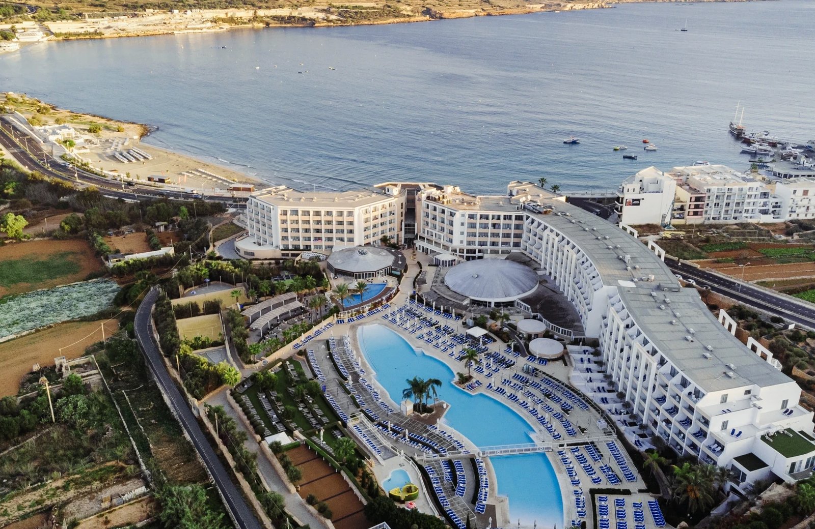 db Seabank Resort + Spa: a large all-inclusive resort beside Mellieħa Bay in northern Malta, with the lagoon-style main pool and the sandy beach across the road.
