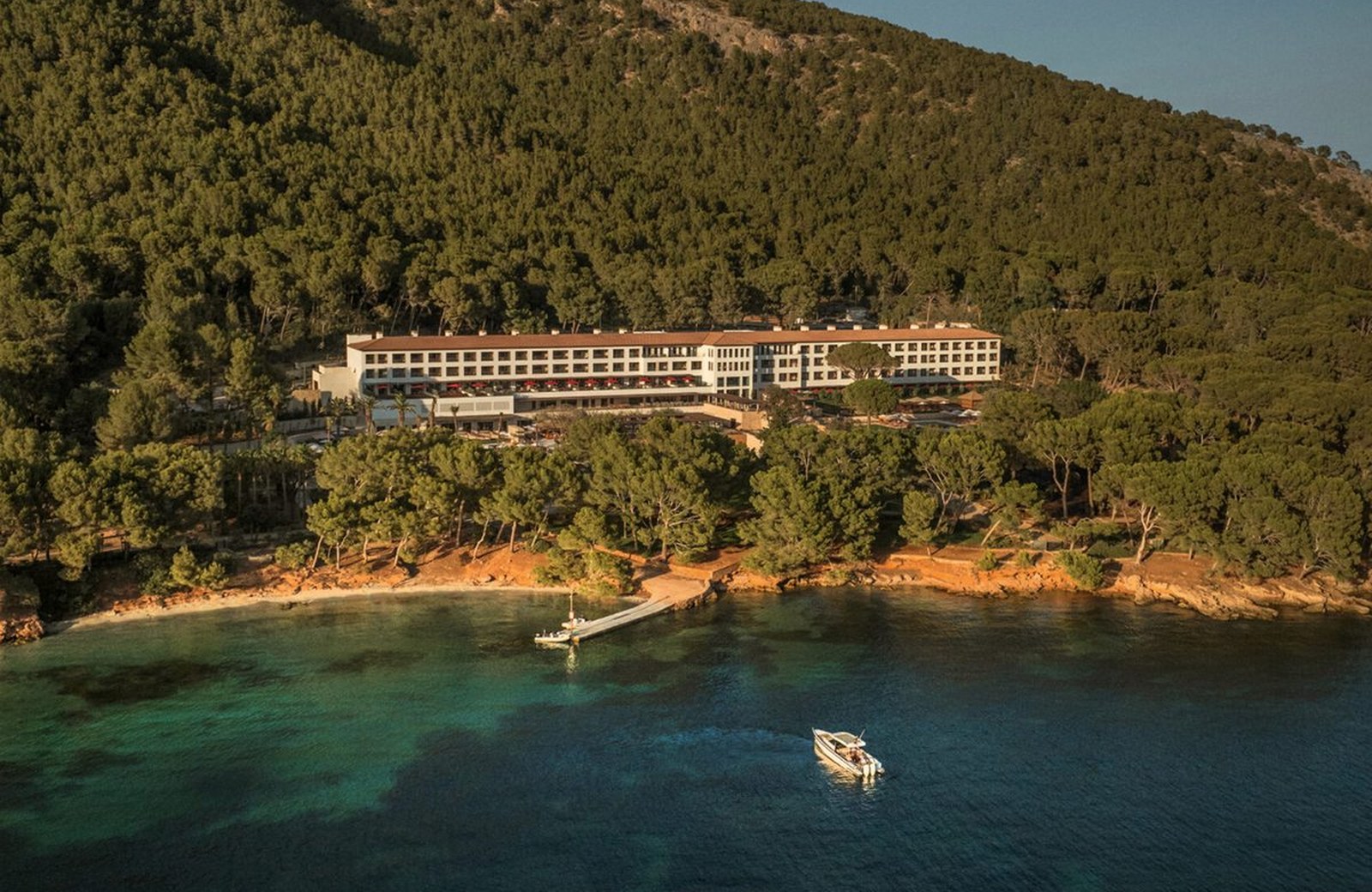 Four Seasons Resort Mallorca at Formentor, its long white building set on a pine-covered hillside above a turquoise cove with a private jetty on the Bay of Pollença.