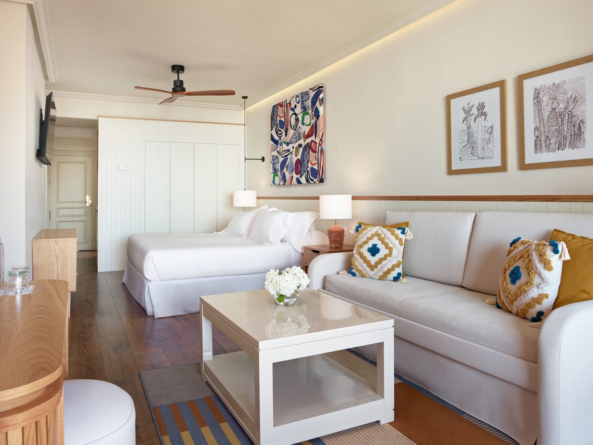 A suite sitting area with cushioned sofas and a coffee table under a sloped ceiling.