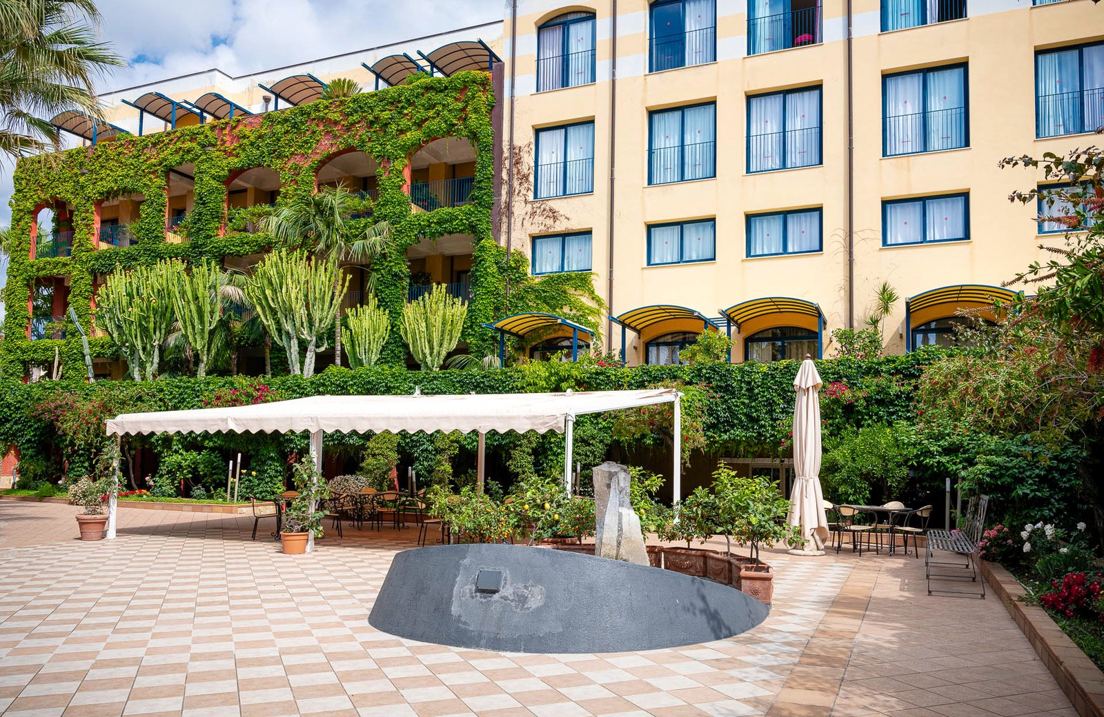 Hotel Caesar Palace, a single hillside hotel building set in gardens above the town of Giardini Naxos in Sicily.
