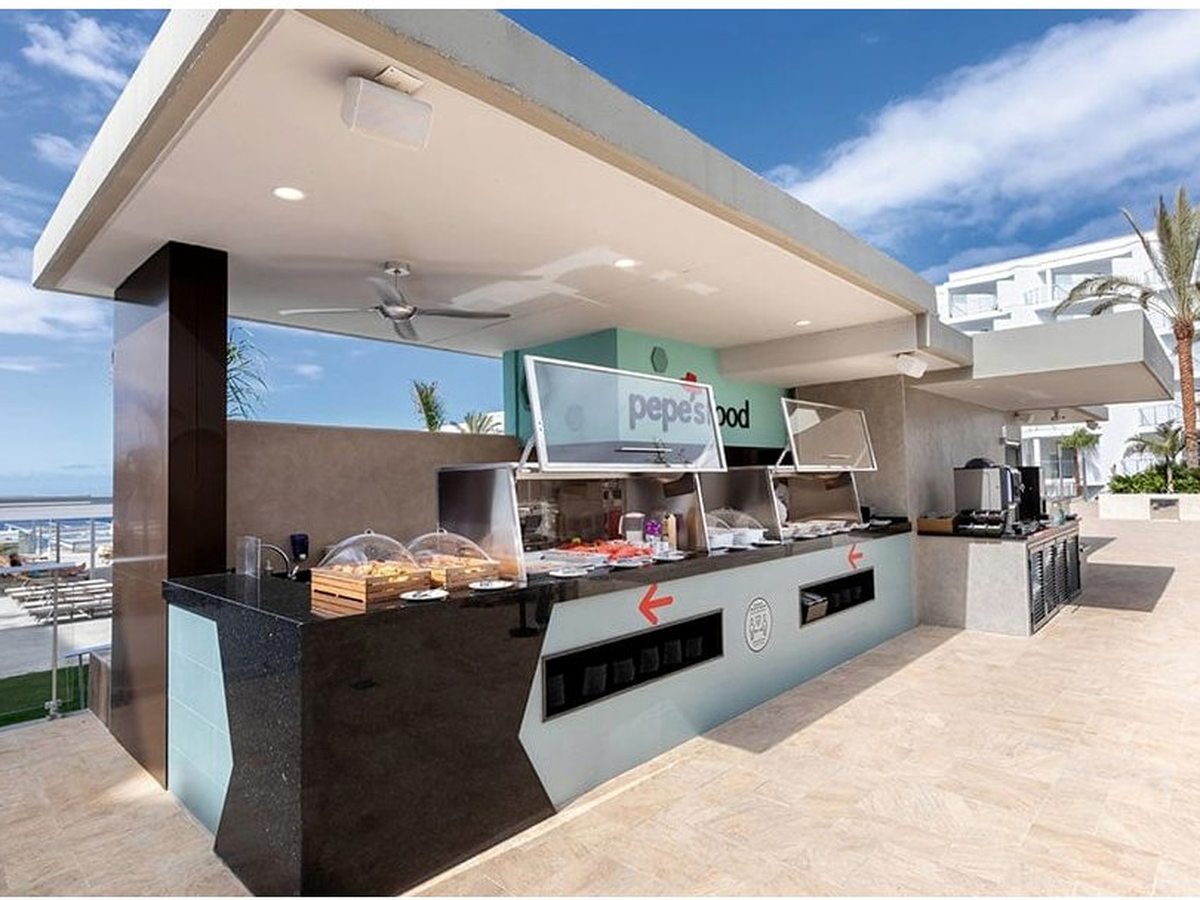 The open-air poolside grill counter signed pepe's food, with a covered servery and sea and pool views behind.