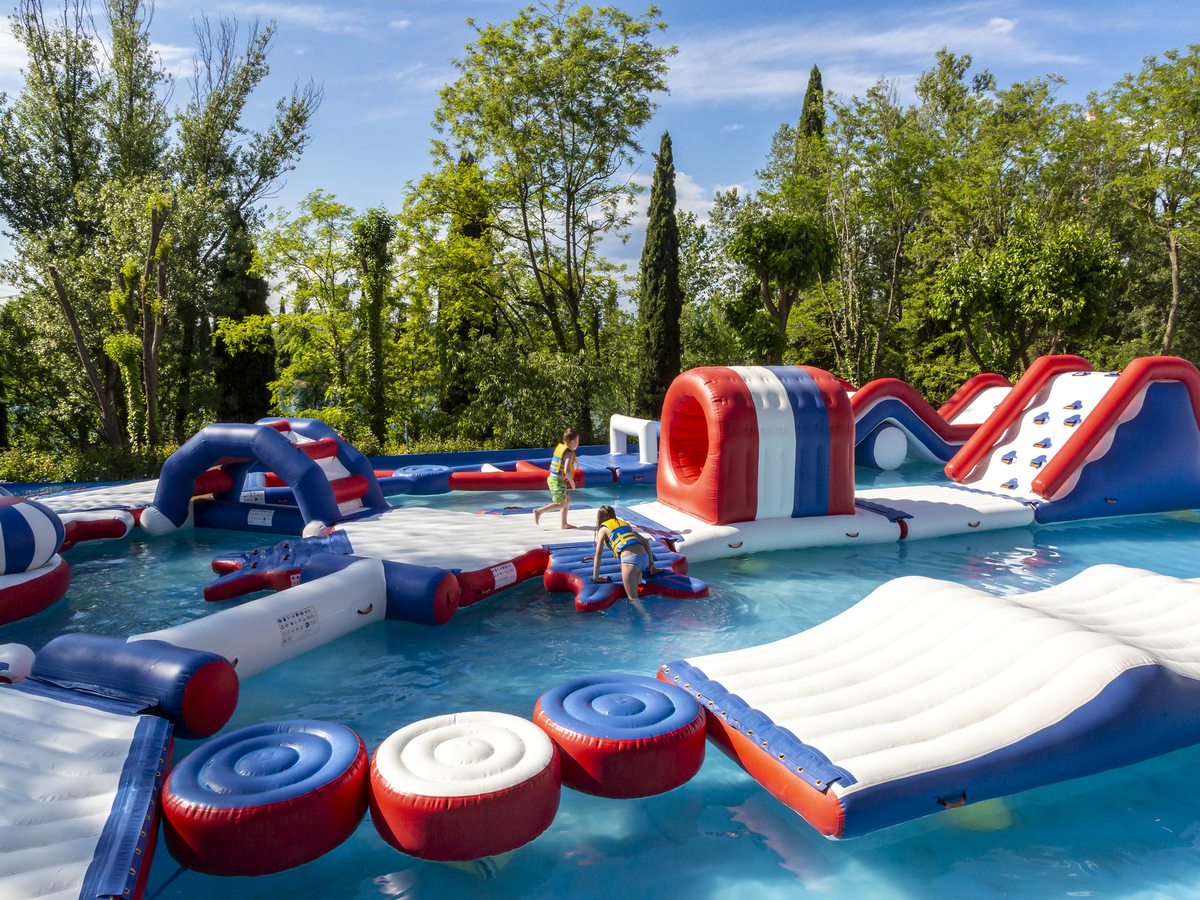 A shallow pool filled with red, white and blue inflatable climbing and sliding shapes.