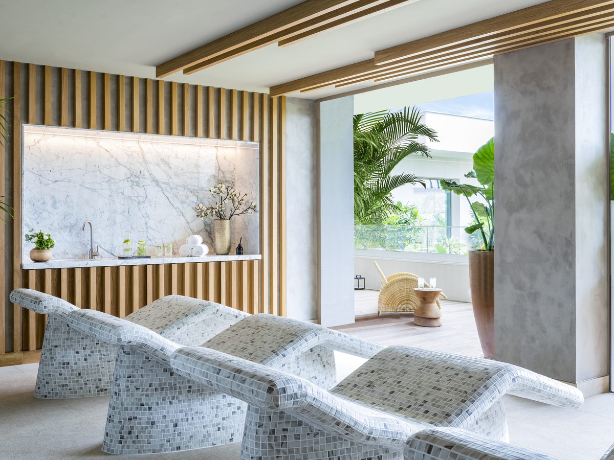 The indoor spa at Ikos Andalusia, mosaic-tiled heated loungers in a bright room opening onto a planted terrace.